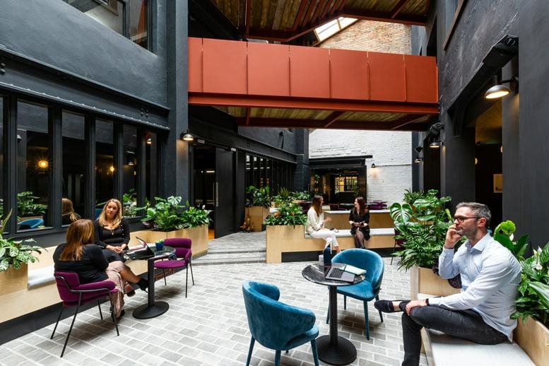 Spacious interior courtyard with modern seating and an industrial red bridge at The Masonry, 151-156 Thomas Street.