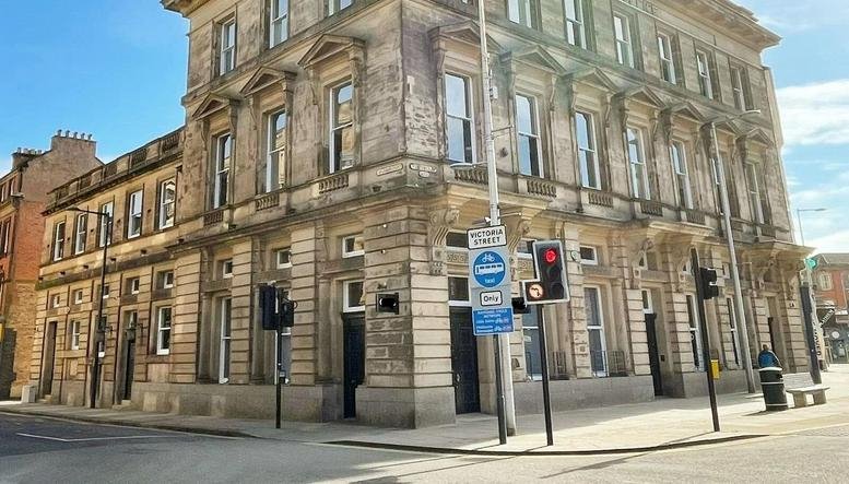 Grand stone exterior facade of The Old Post Office on a sunny corner location.