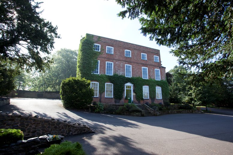 Exterior view of the brick facade and ivy-covered walls at The Old Rectory, Main Street, Glenfield.
