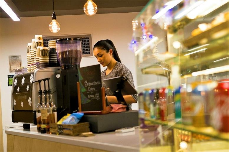 Cafe area at The Poynt North, 45 Wollaton Street, Nottingham with an espresso machine and barista.