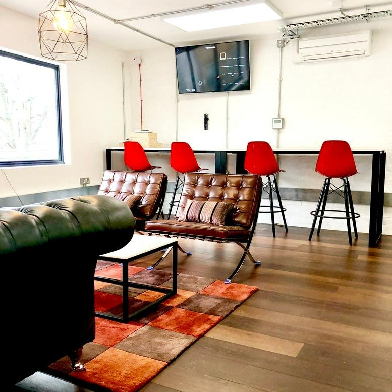 Modern lounge area at The Studio, First Floor, 61-63 Rochester Place with leather chairs and red bar stools.