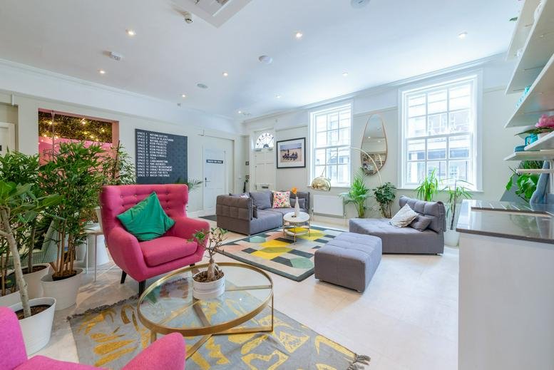 Bright breakout lounge at This is the Space, 68 Quay Street, with pink armchairs and vibrant rugs.