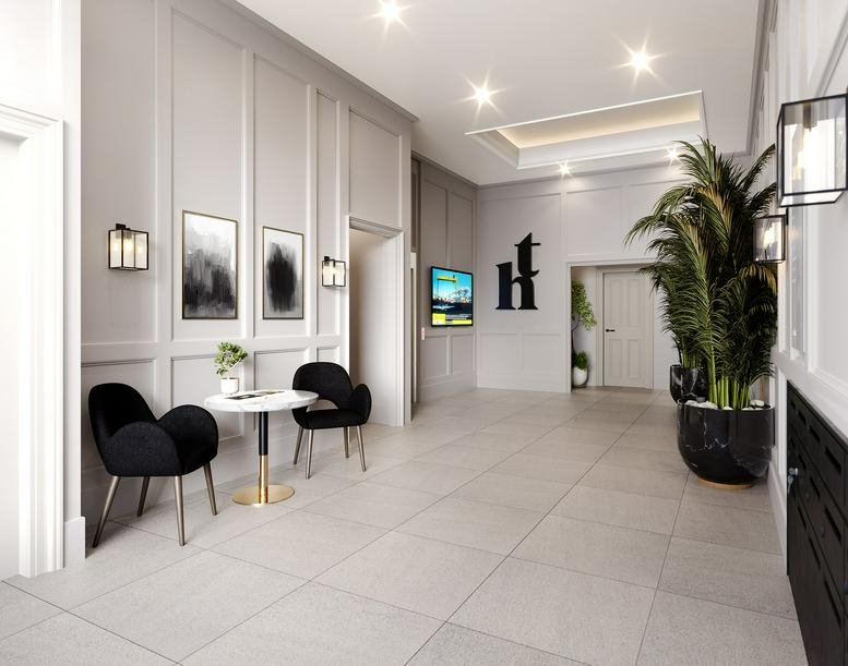 Polished reception area at Thomas House, 14-16 James Street South with grey wood paneling and black lounge chairs.