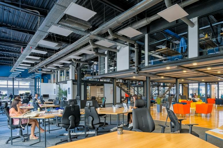 Industrial-style open workspace with exposed ceiling and mezzanine at Tintyava 15-17, Sofia, Bulgaria.