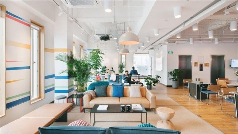 Sunlit communal lounge at Tjuvholmen Alle 1-5 with colorful wall stripes and plush seating.