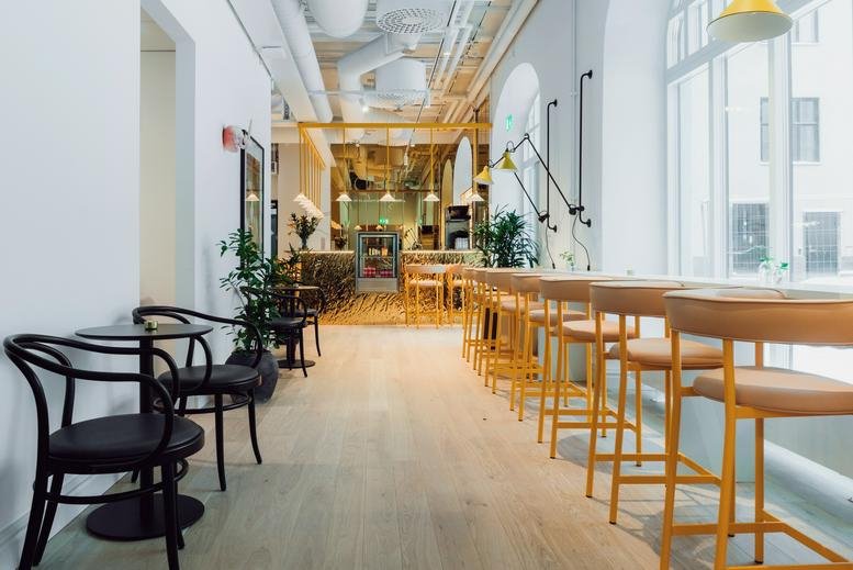 Spacious communal hall at Torsgatan 26, 113 21 Stockholm with high ceilings and café-style seating.