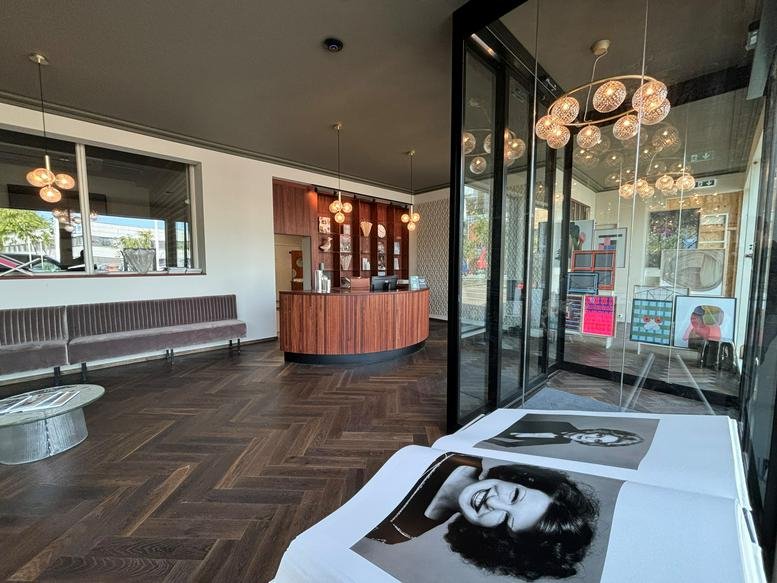 Reception lobby with a curved wood desk, herringbone floors, and stylish bubble chandeliers.