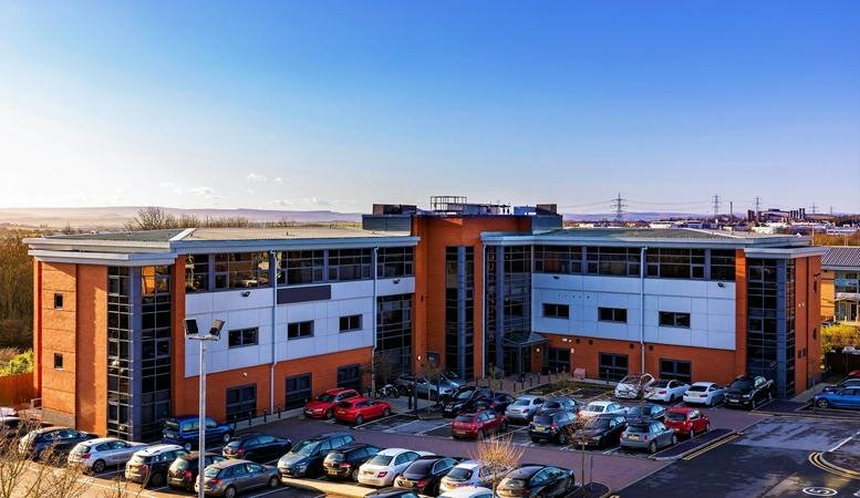 Exterior view of the brick and glass office building at Turnberry Park Road.