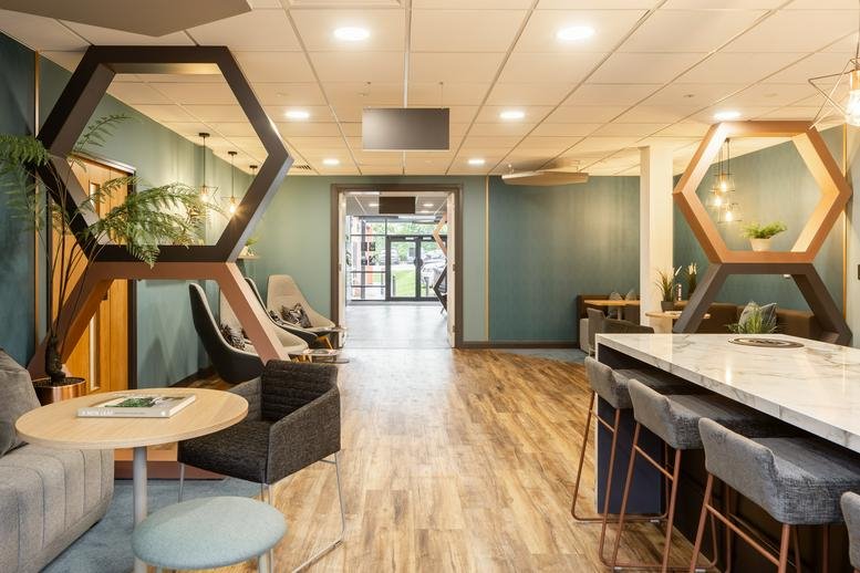 Expansive communal hub with wooden flooring, breakfast bar, and stylish hexagon room dividers.