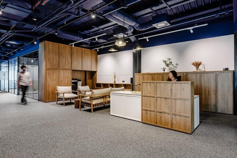 Reception area at Ulica Żelazna 51/53, Building 19, featuring wooden desk and industrial ceiling.