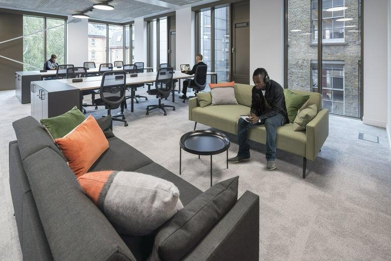 Spacious communal lounge at Verse Building, Old Street, London with sofas and views of the desk area.