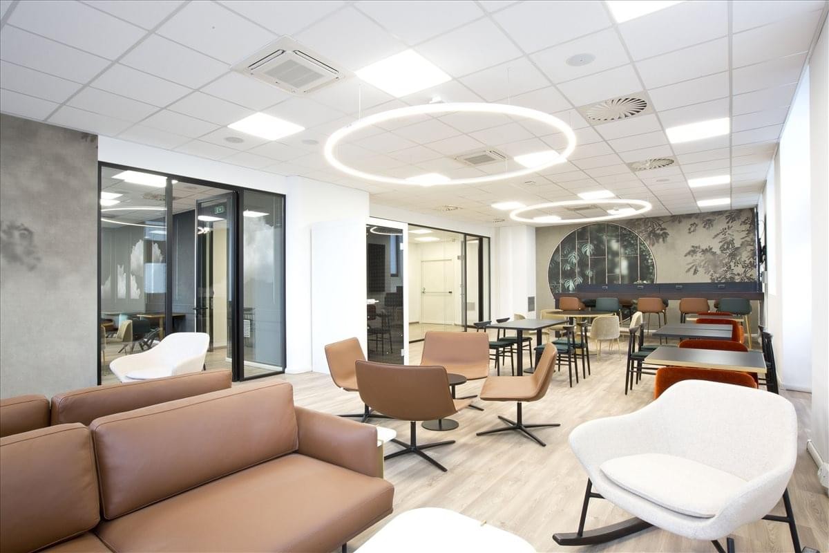 Elegant reception lounge at Via Altabella 17 with leather seating and circular pendant lights.