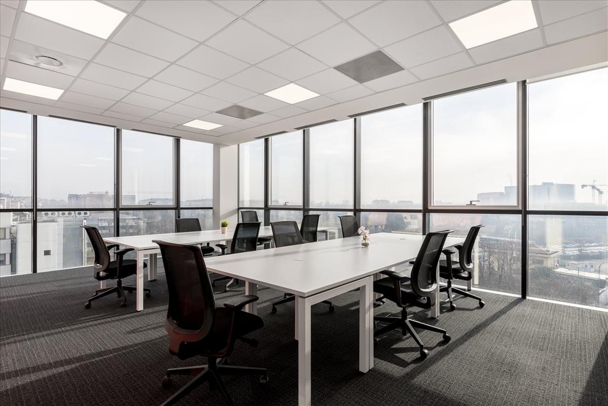 Spacious open-plan workspace at Via Bisceglie 76 with large windows and city views.