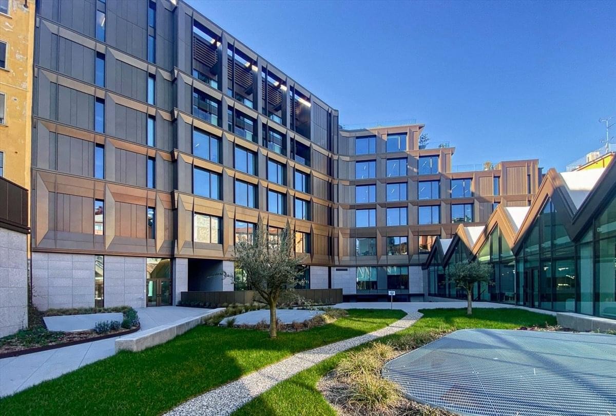 Exterior view of the contemporary bronze-toned building at Via Francesco Melzi d’Eril, 34.