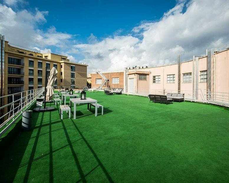 Rooftop terrace with artificial grass and outdoor seating at Via Giuseppe Andreoli 9, Rome.