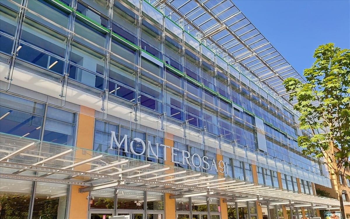 Exterior facade of the glass and steel building at Via Monte Rosa, 91, Milan.