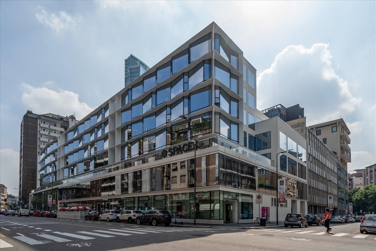 Exterior view of the contemporary glass and concrete building at Via Pola 11, Milan, Italy.