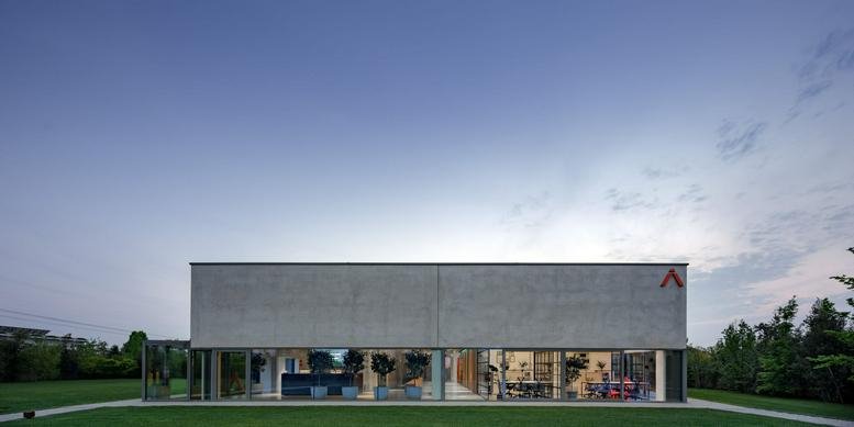 Exterior view of the glass and concrete office building at Via S. Gaetano 113/A, Montebelluna.