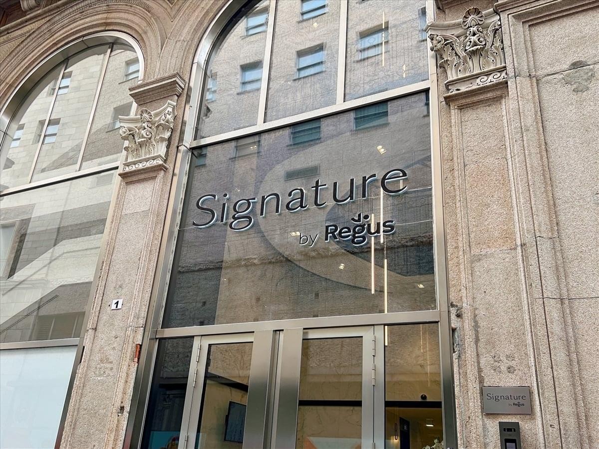 Exterior view of the classic stone facade and glass entrance of Signature at Via San Raffaele 1.