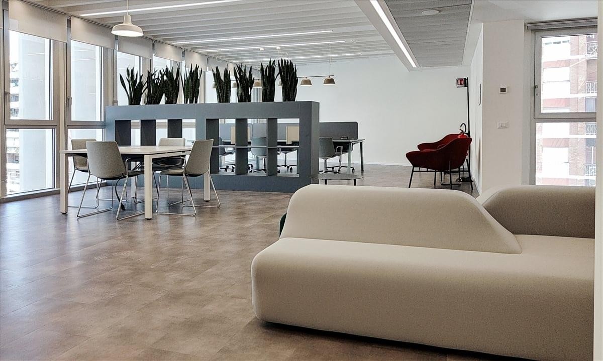 Bright common area at Via Silvio D’Amico n. 40 with stylish furniture and indoor plants.