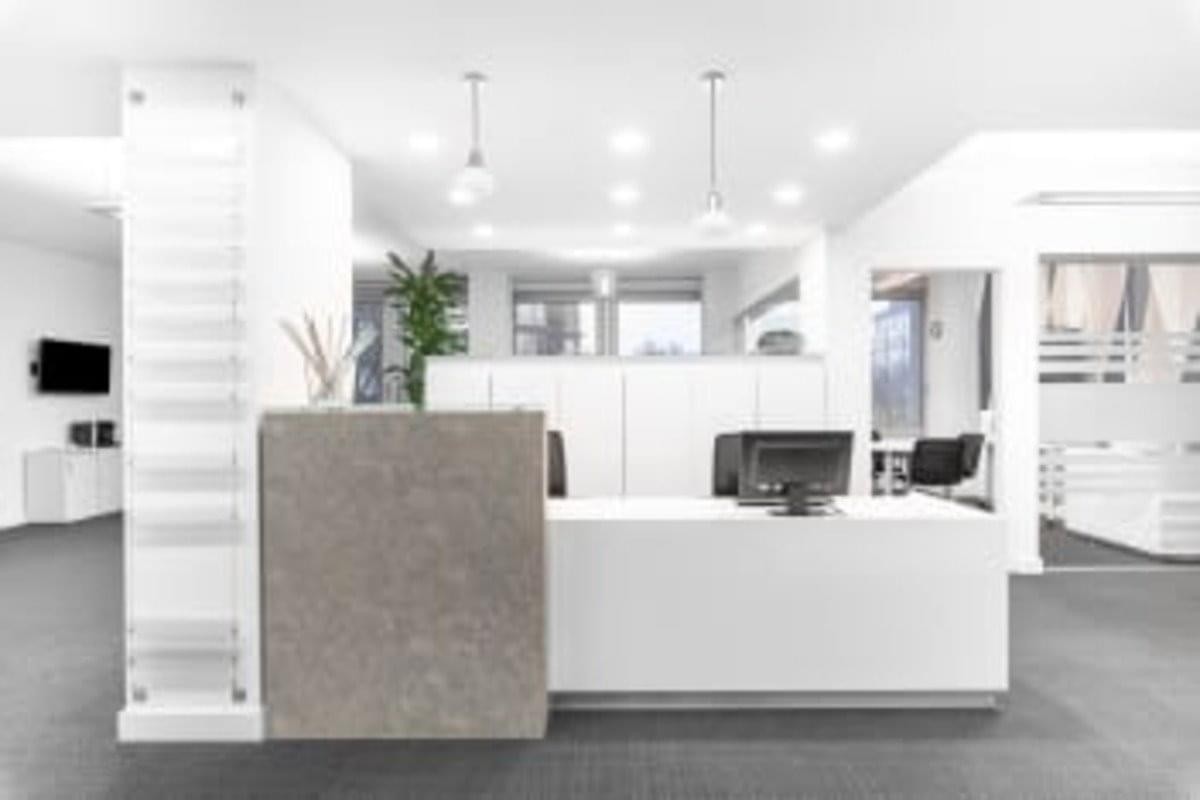 Bright reception desk at Via Tiziano 32, 4th floor, Milan with stone texture and modern pendant lighting.