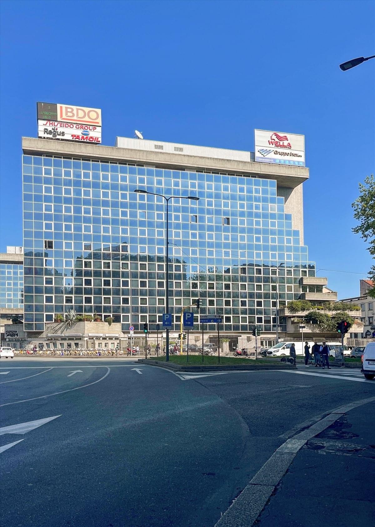 Exterior view of the glass-facade building at Viale Abruzzi 94, Milan, Italy.