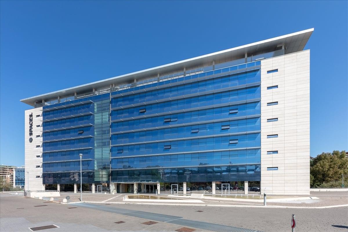 Modern glass-facade exterior of the office building at Viale Luca Gaurico 91/93.