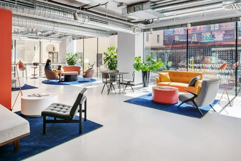 Spacious sunlit lounge at Viale Spartaco Lavagnini 70/72 featuring colorful seating and large windows.