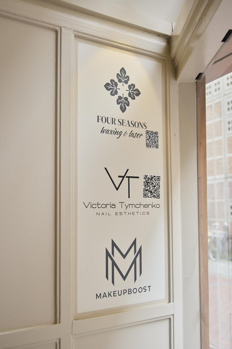 Interior directory sign featuring logos for various beauty and wellness businesses.