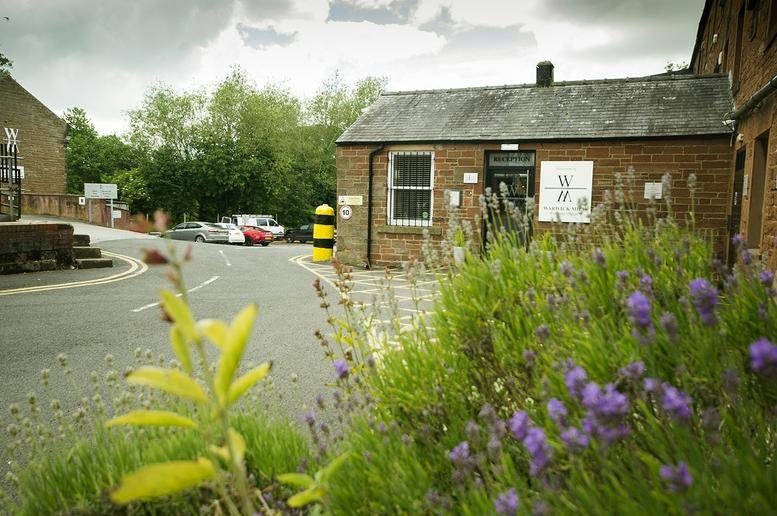 Exterior brick entrance of Warwick Bridge, Carlisle, Cumbria with purple lavender in the foreground.