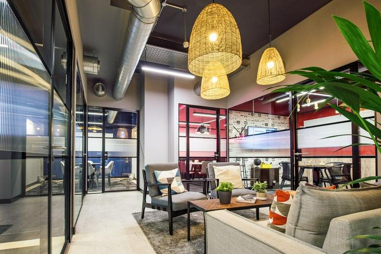 Spacious lounge at Waverley House, 7-12 Noel St, with wicker pendant lights and glass partitions.