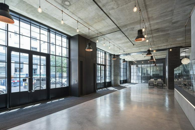 Industrial style lobby with polished concrete floors and large gridded windows.