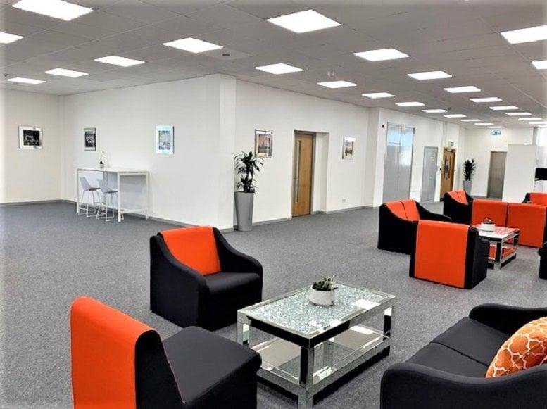 Spacious communal lounge area with orange and black armchairs at Westlink house, 981 Great West Road.
