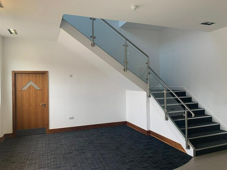 Bright white reception area at Whitehouse Street, Hunslet, Leeds, with a staircase and wood door.