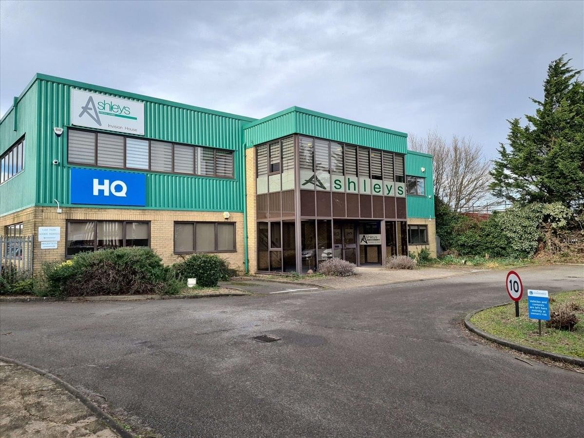 Exterior view of the green and beige facade of Invision House in Hitchin.
