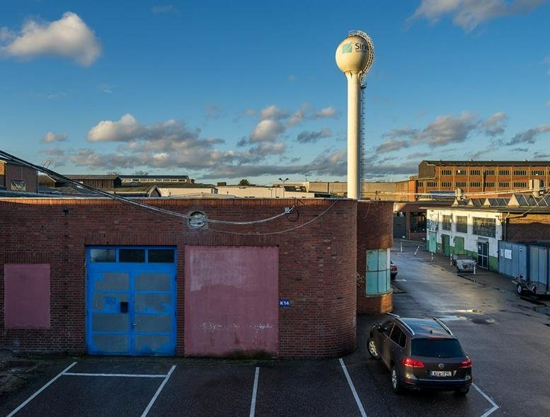 Exterior view of the industrial brick building at Wilhelm-Ruppert-Straße 38 with a prominent white water tower.