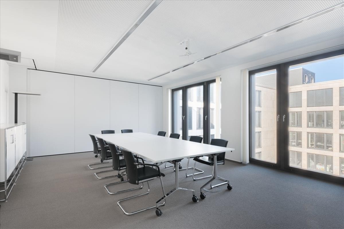 Spacious boardroom at Willy-Brand-Platz 2 featuring a large white table and city views.