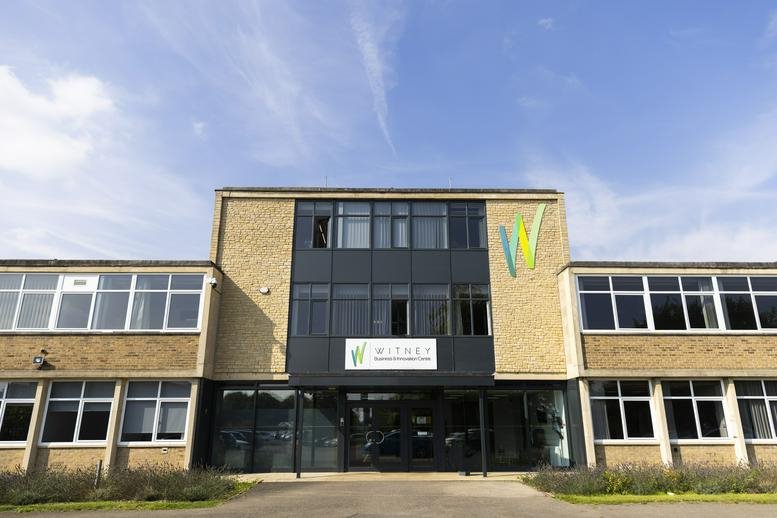 Front-on exterior view of the main building entrance under a clear sky.