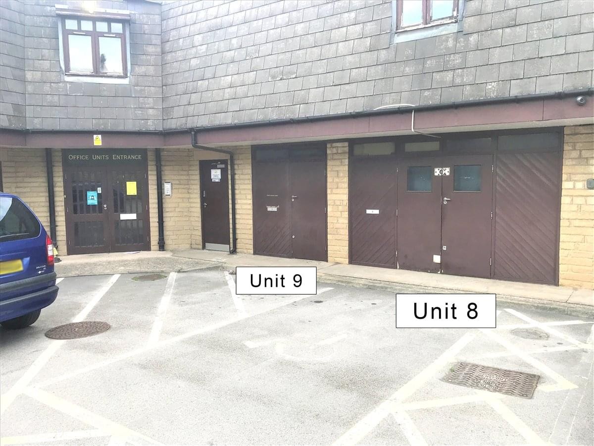 Exterior view of the brick facade and parking area at Woodbourn Business Centre.