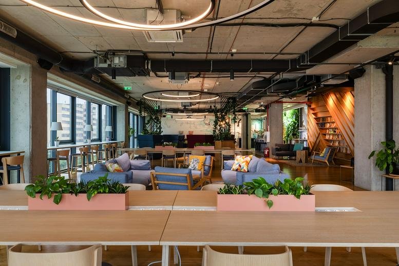 Spacious communal lounge at WorkBetter Tsarigradsko, Ivan Abadjiev Street 2 with plants and hanging circular lights.