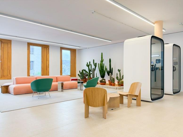 Lounge area at Zürcherstrasse 39, JED, Schlieren featuring peach sofa, green chairs, and large cacti.