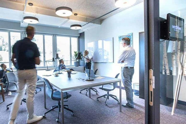 Meeting room at Zug Tech Cluster, Oberallmendstrasse 18 with a whiteboard and central conference table.