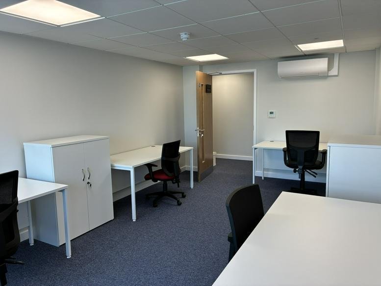 Spacious office suite with white desks and black chairs at South House, 15, Bond Avenue.