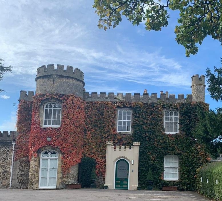 Exterior of the historic flint and stone St Andrews Castle building with red climbing ivy and turrets.