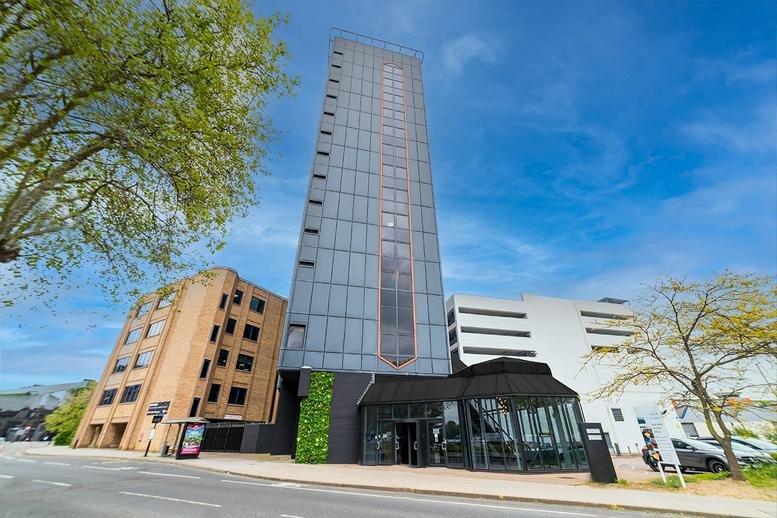 Exterior view of the glass-facade St Clare House, Greyfriars featuring a modern entrance and vertical greenery.