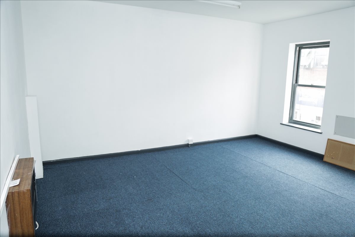 Spacious private office at 129 High Street, Huntingdon with blue carpets and a bright window.