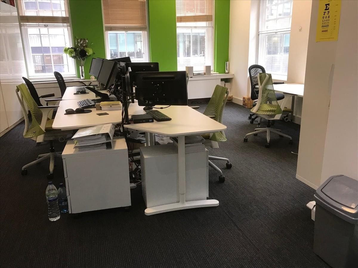 Open-plan office space at 36 Spital Square with green feature walls and modern workstations.