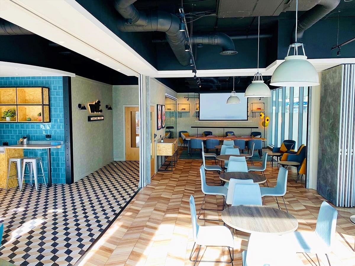 Spacious communal lounge and coworking area at 5 Cavell Street with checkered and wood flooring.