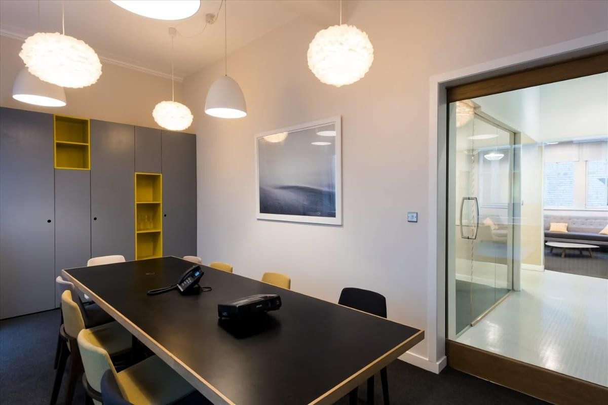 Meeting room at Curated House, 90 Mitchell Street with a black table and round pendant lights.