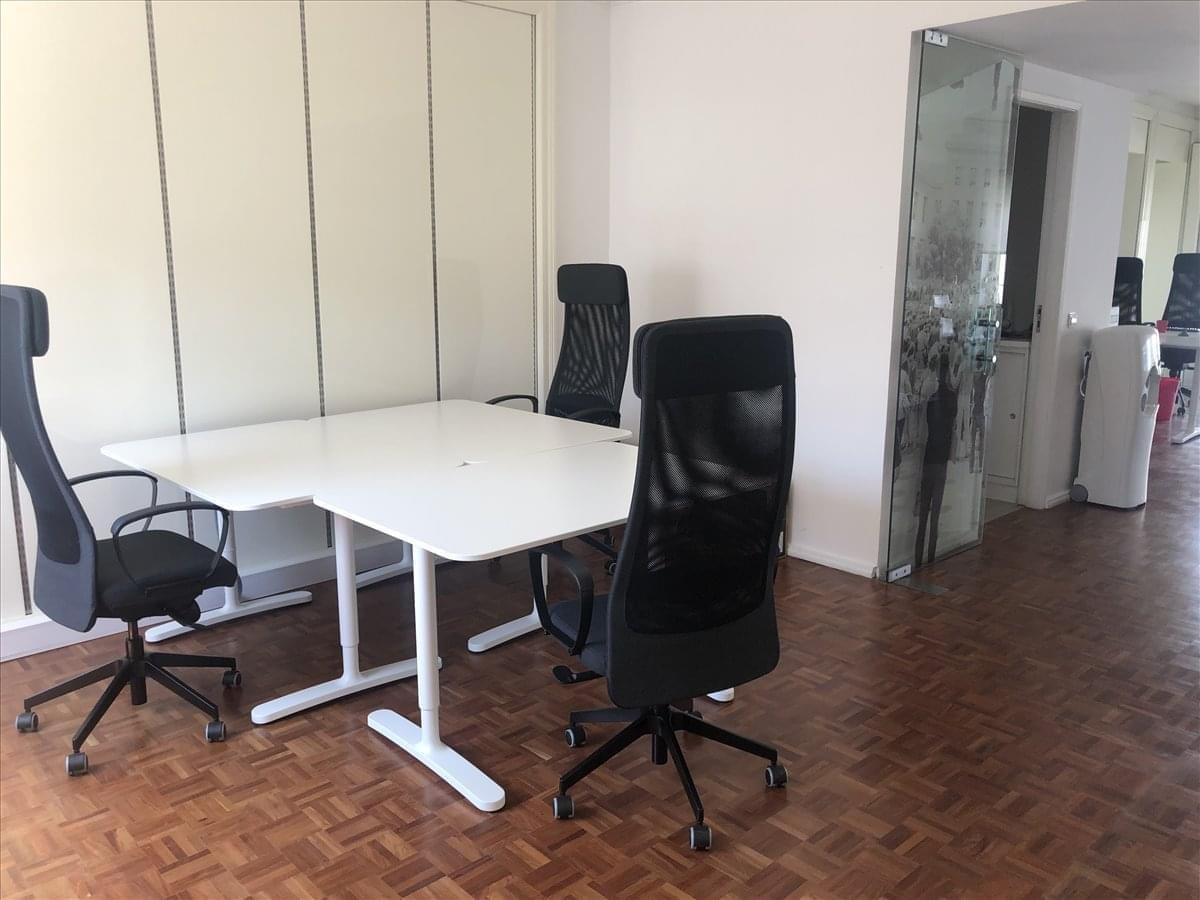 Meeting area with white tables and black mesh ergonomic chairs at Rua Almirante Reis, 54, 5.